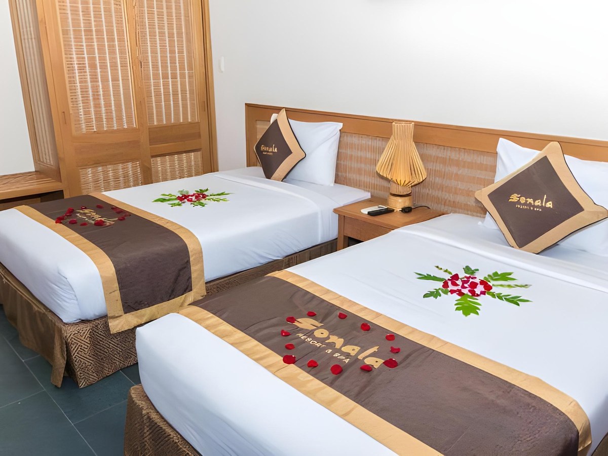 Twin room with two single beds made up with brown runners and a red flower decoration